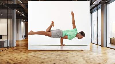 Man practicing balance yoga pose on white studio background Wall mural