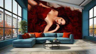 Sexy stylish blonde beautiful woman on the sofa. bouquet of flowers, peonies, pompons. Red dress. Wall mural