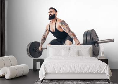 The technique of doing an exercise of deadlift with a barbell of a muscular strong tattooed bearded sports men on a white studio background. Isolate. Wall mural