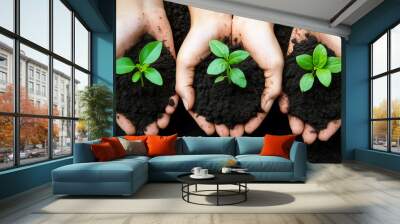 Three hands hold seedlings with soil, emphasizing the importance of nurturing plants and eco-friendly practices Wall mural