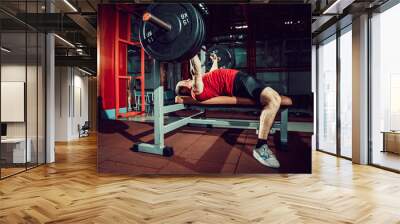 Very Strong man doing bench press workout in gym. Wall mural