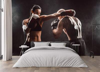 Woman exercising with trainer at boxing and self defense lesson, studio, smoke on background. Female and male fight Wall mural