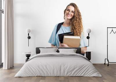 Young smiling student woman holds books while looking at camera. Over white background. Education. Wall mural