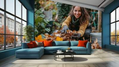 woman raking up autumn leaves in the garden Wall mural