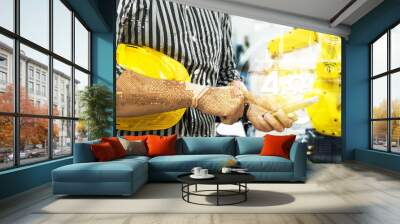 Industry 4.0 internet of things concept. Engineer finger point to smart phone for control blur robot machine arm background , yellow hat and industrial graphic in smart factory. Wall mural