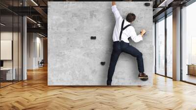 Businessman climbs the wall as a climber, business concept Wall mural