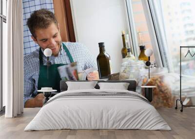 Guy cooking the dish according to the recipe Wall mural