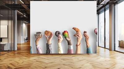 People are holding different desserts in their hands. The concept of food and sweets. Wall mural