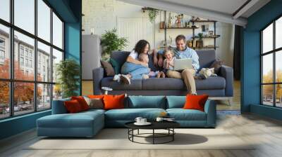 Young beautiful happy family relaxing at home Wall mural