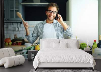 Young guy tries to cook dinner at home Wall mural