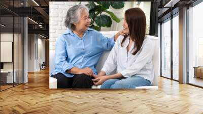 A young woman shares a heartfelt conversation with her mother on a special day, their bond evident in the warmth and affection they express toward each other. Wall mural