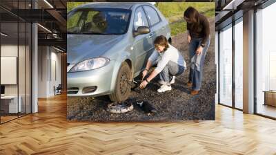 man helping for woman to change broken wheel Wall mural