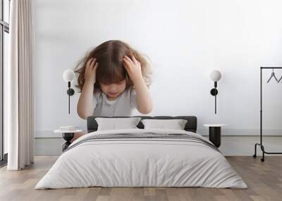 Sad little girl with mental trauma sitting on floor. Wall mural