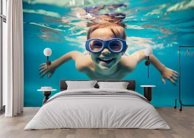 Young boy with goggles swimming underwater in swimming pool Wall mural