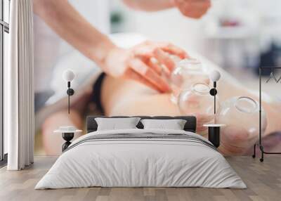 Close-up of a therapist giving cupping treatment. Female laying on chest and relaxing Cupping massage Wall mural