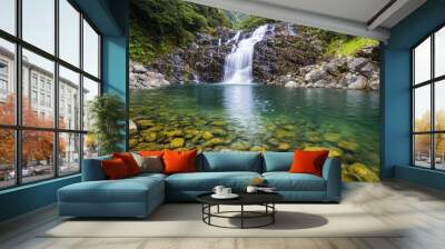 A beautiful waterfall is surrounded by rocks and a small body of water Wall mural