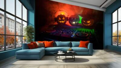 Halloween pumpkin on a dj table with headphones on dark background with copy space. Happy Halloween festival decorations and music concept Wall mural