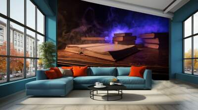 Imagine a picture book of an ancient book opened on a wooden table with a sparkling golden background. With magical power. magic. lightning around a glowing glowing book In the room of darkness Wall mural