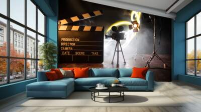 Movie concept. Miniature movie set on dark toned background with fog and empty space. Silhouette of vintage camera on tripod. Wall mural