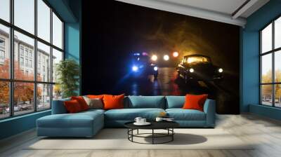 Police car chasing a car at night with fog background. 911 Emergency response police car speeding to scene of crime. Wall mural