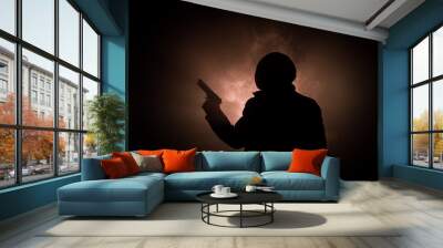 Silhouette of man with assault rifle ready to attack on dark toned foggy background or dangerous bandit in black wearing balaclava and holding gun in hand. Shooting terrorist with weapon theme decor Wall mural