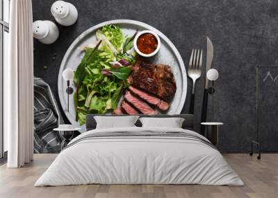 Grilled marbled beef steak with salad in a plate on the kitchen table. With copy space under the text. Wall mural