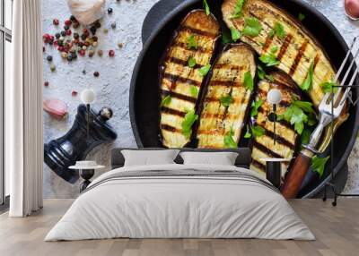 Spicy eggplant grilled in a cast-iron frying pan on a concrete background. Wall mural