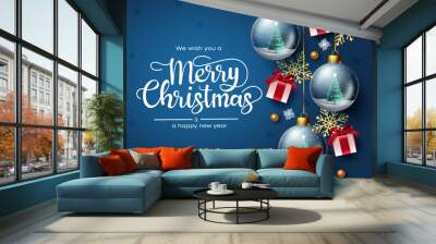 Merry christmas vector design. Merry christmas greeting text with gift, crystal ball and snow flakes element in blue background for holiday season decoration. Vector illustration. 
 Wall mural