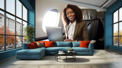 African american businesswoman with laptop on airplane seated in business class. Generative AI. Wall mural