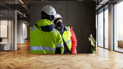 The architect of the building project and the construction manager walk around the interior of the new building Wall mural