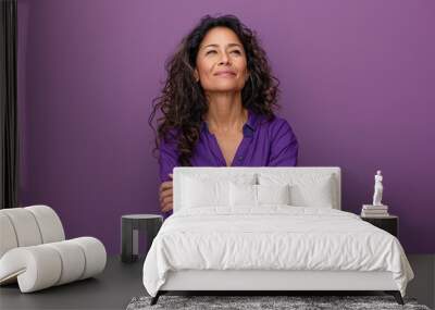 A woman with long hair is wearing a purple shirt and is looking up at the camera Wall mural