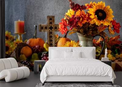 Thanksgiving cornucopia overflowing with fruit nuts pumpkins burning candle and wooden cross Wall mural