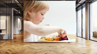 Adorable baby girl eating fresh vegetables Wall mural