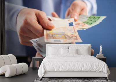 Businessman's  hands exchanging euro on blue background Wall mural