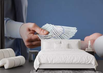 Human hands exchanging money on blue background Wall mural