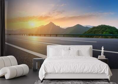 Asphalt road and beautiful mountain with lake at sunset Wall mural