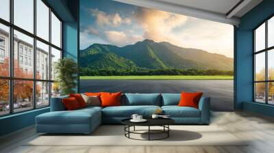 Sunrise over an asphalt road square and verdant mountain with clouds in the sky Wall mural