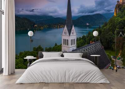 Bled, Slovenia - Aerial panoramic view of the beautiful St. Martin's Parish Church at blue hour with Bled Castle (Blejski Grad) and Julian Alps at the background with amazing clouds and sky Wall mural