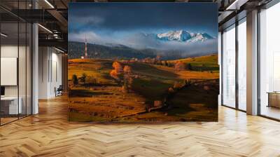 Osturna, Slovakia - Panoramic view on High Tatras mountains National Park on a sunny autumn morning with warm golden sunrise colors on foliage, radio tower and foggy mountains at background Wall mural