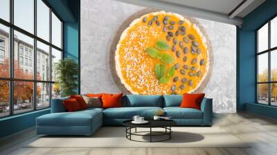 Traditional american sweet pumpkin pie decorated with mint, sesame and pumpkin seeds on a gray concrete background. top view, close up. Wall mural