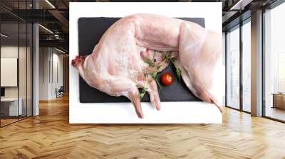 Whole raw rabbit with tomatoes, pea sprouts on a black concrete slate board isolated on white background. Top view. Wall mural