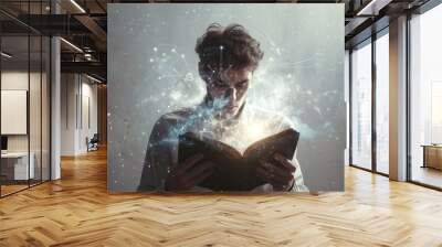 A young man reads a book that emits a bright light and digital effects, creating a futuristic and immersive atmosphere. The scene evokes a sense of exploration and technological magic. Wall mural