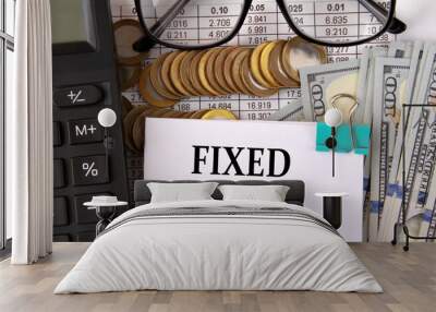 FIXED ASSET - words on a white piece of paper on the background of a calculator, pennies and glasses Wall mural