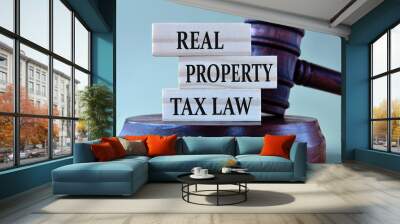 REAL PROPERTY TAX LAW - words on wooden blocks against the background of a judge's gavel with a stand. Wall mural