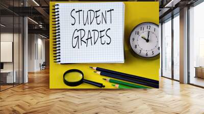 STUDENT GRADES - words in a white notebook with an alarm clock, pencils and magnifying glass in the background Wall mural