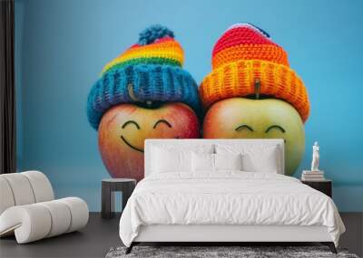 Two apples with smiling faces and colorful rainbow hats against a vibrant blue background. Great for cheerful themes, kids' products, and creative designs. Wall mural