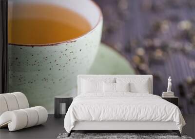 Cup of green tea and leaves of dry green tea on a brown wooden table. Superfood concept. Wall mural