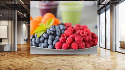 Fruit and berry smoothies and green smoothie. Fresh apricots, raspberries and blueberries on an oval metal plate. Gray background. Wall mural