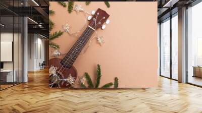 Festive composition ukulele guitar fir branches and lights of Christmas garland on a beige background space for text Wall mural