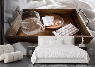 Wooden tray with pills, vitamins or supplements and water glass Wall mural